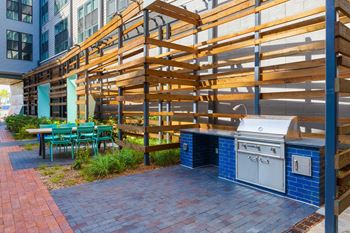 a patio with a barbecue grill and a table with chairs at The Chase at Bryant Street, Washington District of Columbia